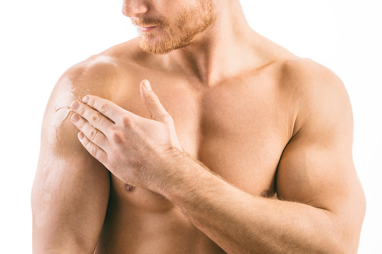 a man is rubbing testosterone gel on his shoulder